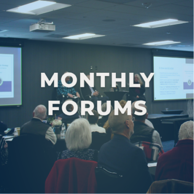 Three people standing on a stage holding a microphone and speaking to a medium-size crowd. Image reads, "MONTHLY FORUMS"