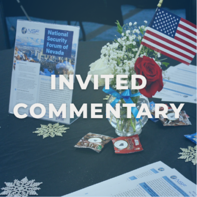 Vase of red, blue, and white flowers with a flag on a table, flyers with information, and decorative snowflakes and candy on the table.
